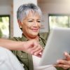 Happy older woman relaxing on the sofa with tablet